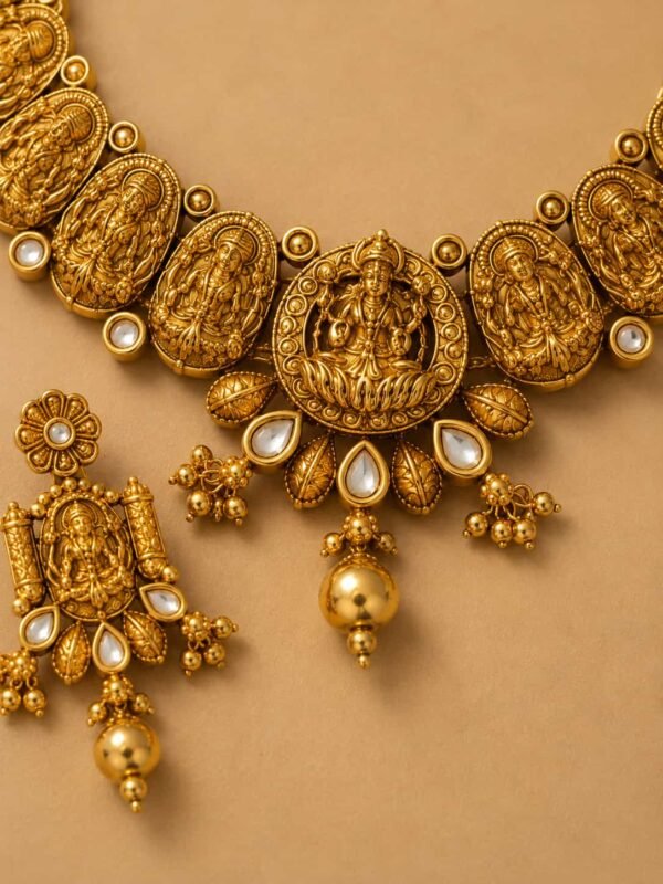 Close-up of Aaradhya Lakshmi temple necklace medallion with antique gold detailing and white stones