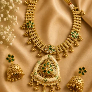 Rajshree Heritage green gold-tone necklace set with matching jhumka earrings on satin